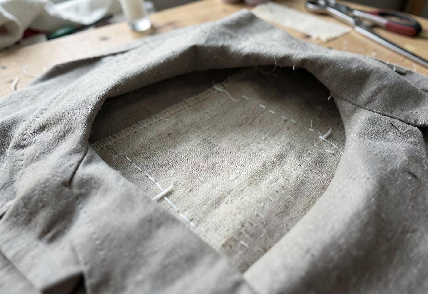 Inside of an unfinished jacket showing a floating canvas and basting stitches